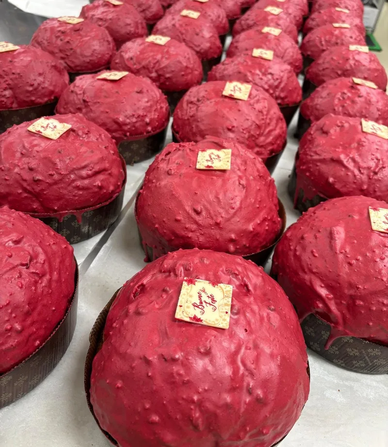 Panettoni con la glassa rossa e la placchetta di cioccolato «Buone Feste»