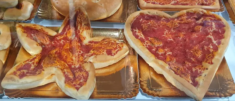 Pizza a forma di stella e pizza a forma di cuore sul banco