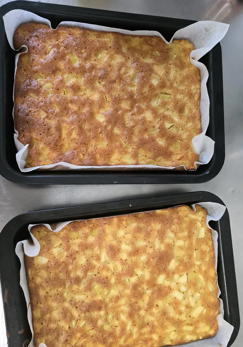 Due teglie di torta di mele appena cotta, con i pezzi di mela in superficie